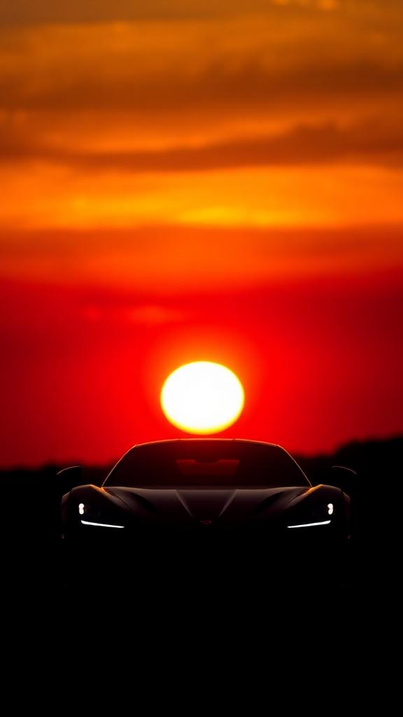 Silhouette of an exotic car against a warm sunset